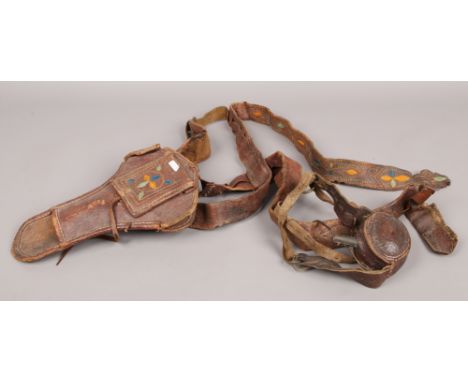 An 18th Century powder flask in lather holder, along with a leather gun holster on belt, with coloured embroidery