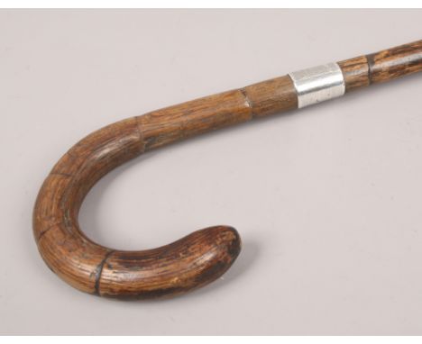 A silver banded walking stick with curved handle, assayed London.