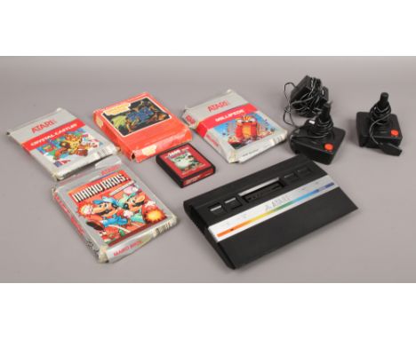 A Retro Atari 2600 gaming console along with two oriental joysticks, power supply and five games to include Mario Bros, Cryst