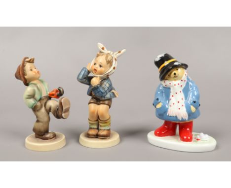 Two M. J. Hummel Goebel figures, one a boy with umbrella the other a girl with headscarf, along with a Coalport figure Paddin