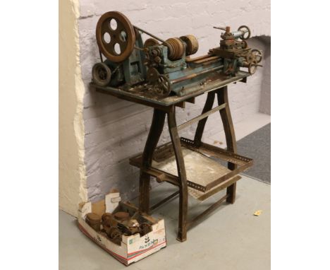 A vintage lathe on stand with accessories.
