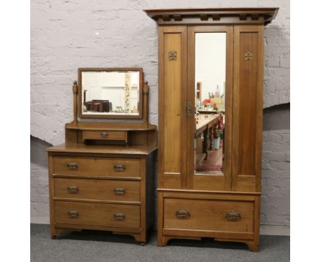 A carved oak Arts and Crafts three part bedroom suite; consisting of mirror front wardrobe, matching dressing table and doubl