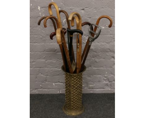 A brass stick stand with contents of walking sticks to include curved handle examples etc.