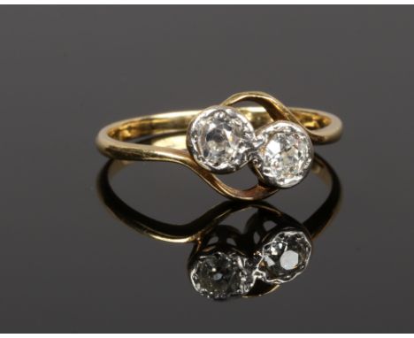 An 18ct gold and diamond two stone cross over ring, set with old European cut stones, stones totalling approximately .40ct, s