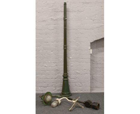 A vintage cast iron street light, along with a steel corner light and a modern garden light column base.