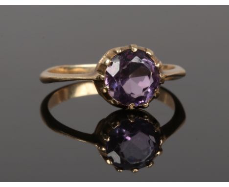 A 19th century gold ring set with a large faceted amethyst stone, size O.