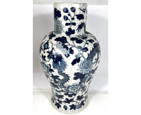 A Chinese inverted baluster crackle glaze vase decorated in blue and white with dragons and flowering branches, impressed sea