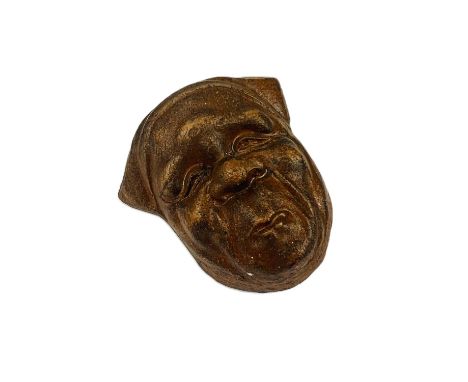 A Japanese pottery netsuke in the form of a face. 
