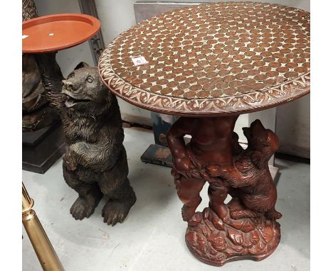 A circular occasional table on resin stand, the top covered with coins; a "Black Forest" style bear holding a circular dish; 