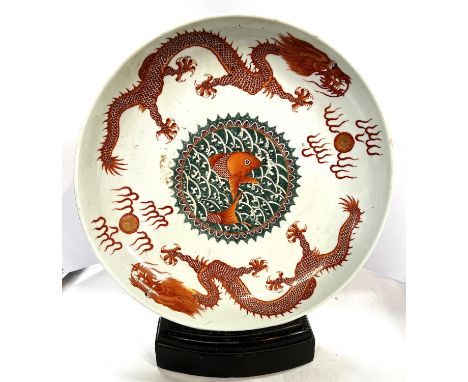 A Chinese charger decorated with burnt orange dragons with a central tableau of a fish in green sea waves, gilt and burnt ora