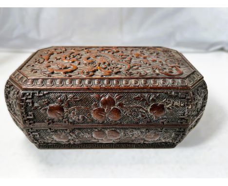 An intricately carved Chinese Zitan type wood box, octagonal with dragons and mythical beasts to the top, flowers/fruits to t