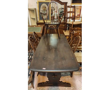 An Ercol style dining suite comprising refectory table and 6 (4+2) hoop and stick back dining chairs 