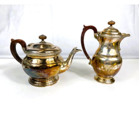 A circular squat hallmarked silver teapot with shell spout and circular foot with matching hot water jug, Birmingham 1966, 38