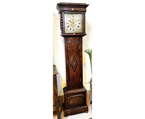 An early 20th century oak longcase clock with barley twist columns to the hood, with square brass dial and spring driven West