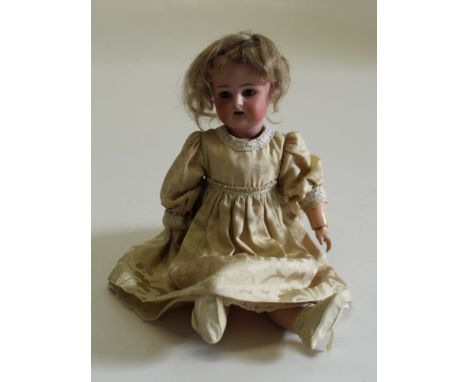 An early 20th century 13'' Kammer and reinhardt bisque head doll. Sleeping hazel eyes, open mouth and painted features. Compo