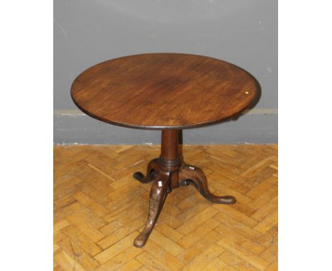 A George III mahogany tripod table, the circular snap top raised on a gunbarrel column and pierced downswept legs. 91cm diame