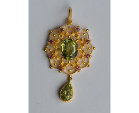 An Antique peridot and ruby circular pendant in claw mount. Approx. 3.2 grams. Est. £350 - £450.
