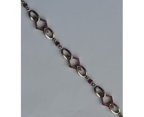 A fancy ruby and diamond two colour gold bracelet with concealed clasp and safety chain. Approx. 26 grams. Est. £2500 - £3500