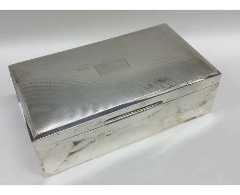 A rectangular silver engine turned cigarette box with fitted interior. Approx. 530 grams. Est. £50 - £80.