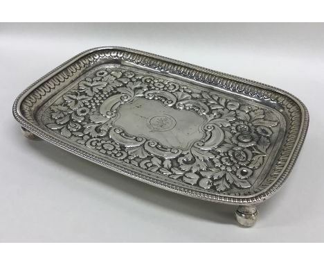 An Irish silver embossed teapot stand with floral decoration. Approx. 313 grams. Est. £250 - £300.