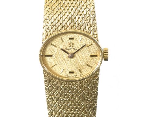 A 1960s 18ct gold ladies Omega wristwatchThe oval shaped gilt textured dial with baton hour markers, signed Omega, within the