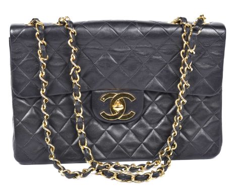 A Chanel Jumbo Classic Flap BagThe black quilted lambskin exterior with gold-tone hardware and large CC twist lock clasp, dou