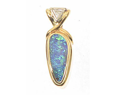 An opal and diamond pendantThe freeform boulder opal collet with triangular shaped diamond surmount, stamped 750 to reverse, 