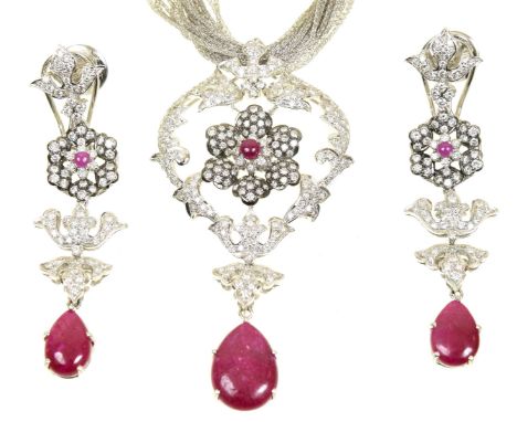 A ruby and diamond suite of jewelleryComprising a necklace, designed as a pear shaped ruby drop suspended from a floral brill