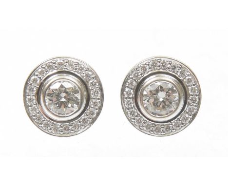 A pair of diamond halo earringsEach designed as a brilliant cut diamond collet within a similarly cut diamond surround, estim