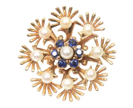 A 1960s sapphire and cultured pearl brooch by Cropp & FarrThe cultured pearl and circular shaped sapphire floral cluster atop