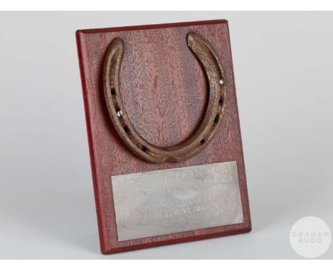 Shoe worn by the racehorse Machiavellian,mounted on a wooden plaque with easel support and set with an engraved metal plaque,