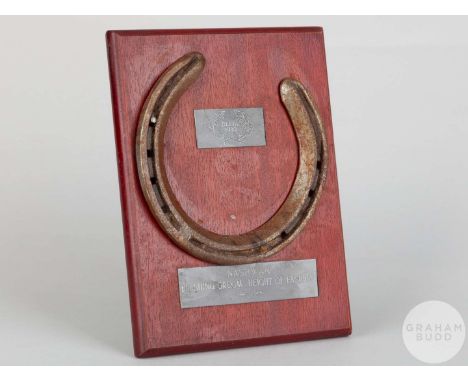 Shoe worn by the racehorse Nashwan,mounted on a wooden plaque with easel support and set with engraved metal plaques, 20 by 1