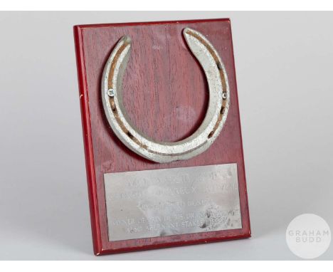 Shoe worn by the racehorse Monaassib,mounted on a wooden plaque with easel support and set with an engraved metal plaque, 20 