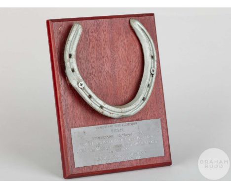 Shoe worn by the racehorse Ribot,mounted on a wooden plaque with easel support and set with an engraved metal plaque, 20 by 1