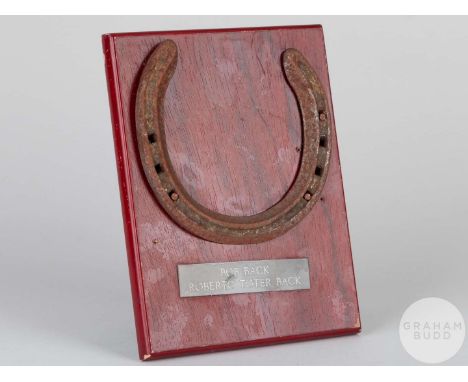 Shoe worn by the racehorse Bob Back,mounted on a wooden plaque with easel support and set an engraved metal plaque, 20 by 15c