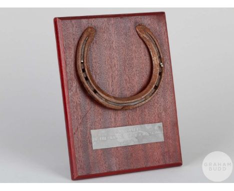 Shoe worn by the racehorse Singspiel,mounted on a wooden plaque with easel support and set with an engraved metal plaque, 20 