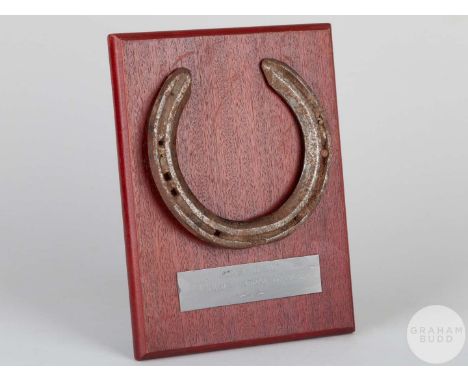 Shoe worn by the racehorse Pennekamp,mounted on a wooden plaque with easel support and set with an engraved metal plaque, 20 