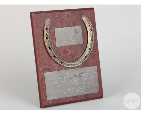Shoe worn by the racehorse Le Filou,mounted on a wooden plaque with easel support and set with engraved metal plaques, 20 by 