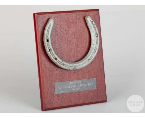 Shoe worn by the racehorse Habitat,mounted on a wooden plaque with easel support and set with an engraved metal plaque, 20 by