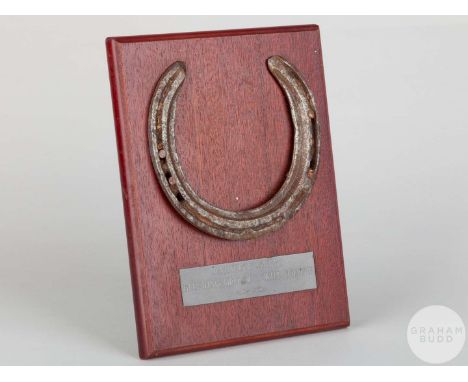 Shoe worn by the racehorse Rainbow Quest,mounted on a wooden plaque with easel support and set with an engraved metal plaque,