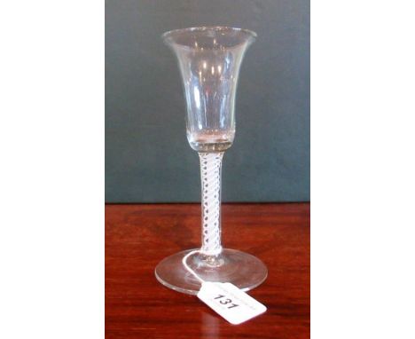 A 19th century drinking glass, having a bell shaped bowl, ribbon and lattice double helix stem on conical base, 17cm tall.