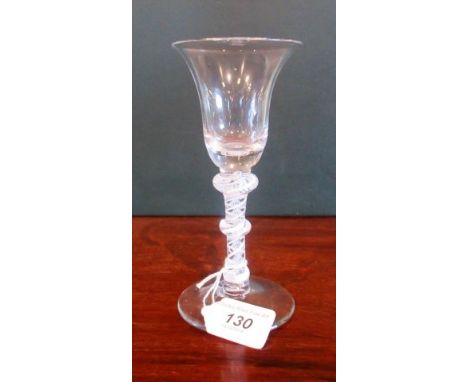 A 19th century drinking glass, having bell shaped bowl, ribbon and lattice corkscrew knop stem on conical base, 17cm tall.