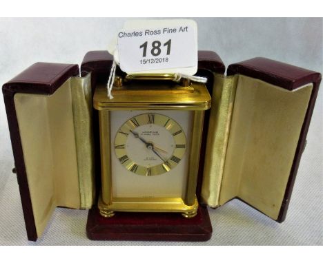 A contemporary travelling carriage alarm clock, with eight day movement, contained in a faux leather case.