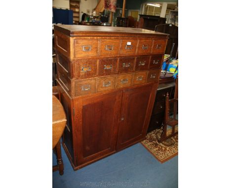A Ministry Office Cabinet with moulded top over fifteen index card drawers, over lower opposing, pair of single panel doors o