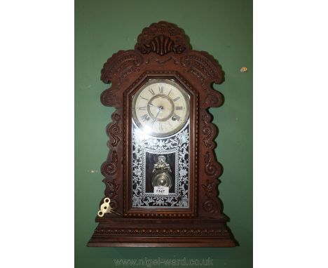 An American Gingerbread style Clock by the Ansonia Clock CO., New York, USA. ornate fretcut, shaped surround with scroll and 