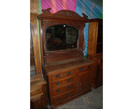 An arts and crafts Oak mirror back Sideboard, having carved pediment top on moulding over arch top, large mirror over shaped 