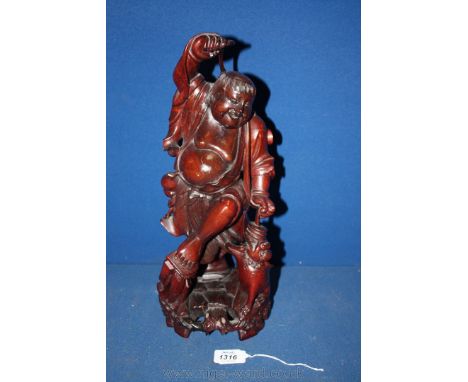 A large hardwood Chinese Carving, circa 1880, depicting Hotei, the God of contentment dancing and playing with a temple dog, 