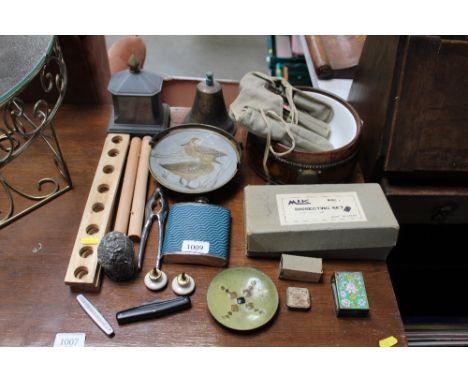 A collection of metalware to include hip flask, bell, nutcrackers, enamel decorated dish etc.