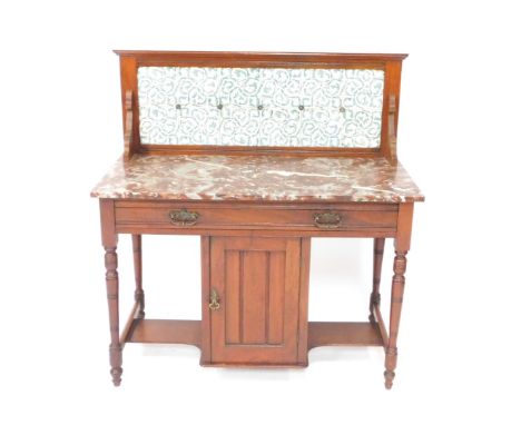 A Victorian walnut wash stand, with a foliate blue tile splash back, veined red marble top, over a long drawer and central cu
