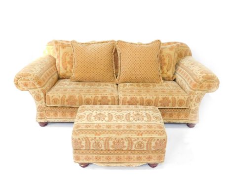 A two seater sofa by Mark Webster, with tapestry upholstery and having shaped back, scroll arms and cushion seats, raised on 